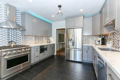 This is an example of a medium sized contemporary u-shaped enclosed kitchen in San Francisco with a built-in sink, shaker cabinets, grey cabinets, engineered stone countertops, multi-coloured splashback, porcelain splashback, stainless steel appliances, dark hardwood flooring, no island and black floors.