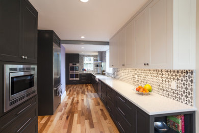 Large trendy l-shaped medium tone wood floor eat-in kitchen photo in Boston with a farmhouse sink, beaded inset cabinets, gray cabinets, quartz countertops, gray backsplash, mosaic tile backsplash, stainless steel appliances and no island