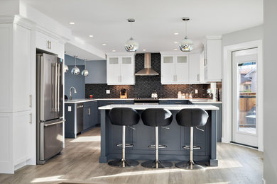 Example of a large transitional u-shaped medium tone wood floor and gray floor eat-in kitchen design in Other with shaker cabinets, quartz countertops, black backsplash, glass tile backsplash, stainless steel appliances, an island, white countertops, an undermount sink and blue cabinets