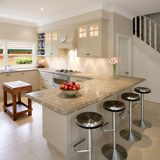 Design ideas for a transitional u-shaped kitchen in Sydney with a drop-in sink, shaker cabinets, beige cabinets, granite benchtops, beige splashback, stainless steel appliances, ceramic floors, a peninsula and beige benchtop.