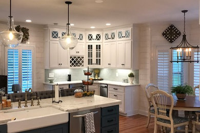 Eat-in kitchen - mid-sized transitional u-shaped medium tone wood floor and brown floor eat-in kitchen idea in Atlanta with an island, a farmhouse sink, shaker cabinets, white cabinets, stainless steel appliances, subway tile backsplash and quartz countertops