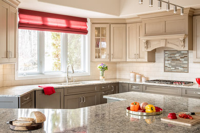 Ejemplo de cocina comedor clásica con puertas de armario marrones, encimera de granito, salpicadero beige, salpicadero de azulejos de cerámica y una isla