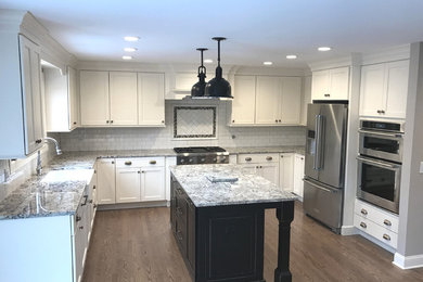 Inspiration for a large timeless u-shaped dark wood floor and brown floor open concept kitchen remodel in Chicago with shaker cabinets, white cabinets, granite countertops, white backsplash, an island, a farmhouse sink, subway tile backsplash and stainless steel appliances