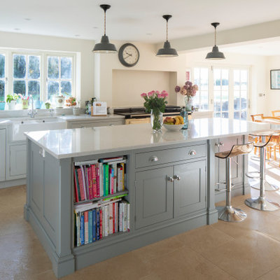 Inspiration for a mid-sized timeless u-shaped limestone floor and beige floor eat-in kitchen remodel in Hampshire with shaker cabinets, gray cabinets, granite countertops, white backsplash, stone slab backsplash, an island, white countertops and a farmhouse sink