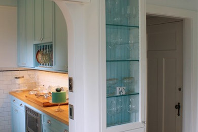 Mid-sized elegant galley marble floor kitchen pantry photo in Vancouver with an undermount sink, flat-panel cabinets, blue cabinets, quartz countertops, white backsplash, ceramic backsplash, stainless steel appliances and an island