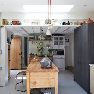 Design ideas for a medium sized farmhouse single-wall kitchen in Hertfordshire with a submerged sink, flat-panel cabinets, blue cabinets, white splashback, an island, grey floors and white worktops.