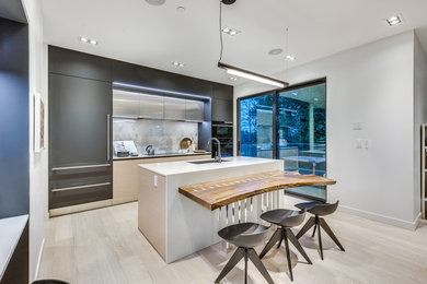 Small minimalist eat-in kitchen photo in Vancouver with flat-panel cabinets and an island