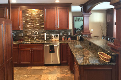 Example of a mid-sized classic u-shaped ceramic tile and brown floor eat-in kitchen design in Other with an undermount sink, flat-panel cabinets, dark wood cabinets, quartz countertops, multicolored backsplash, glass tile backsplash, stainless steel appliances and multicolored countertops