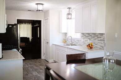 Example of a mid-sized trendy galley porcelain tile and brown floor eat-in kitchen design in Austin with a double-bowl sink, raised-panel cabinets, white cabinets, quartzite countertops, multicolored backsplash, glass sheet backsplash, stainless steel appliances, no island and white countertops