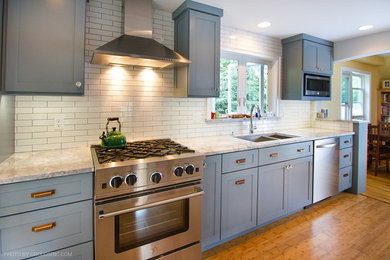 Example of a mid-sized trendy galley bamboo floor kitchen design in Boston with an undermount sink, shaker cabinets, blue cabinets, granite countertops, white backsplash, subway tile backsplash and stainless steel appliances