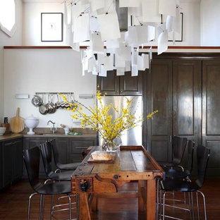 This is an example of a mid-sized country single-wall kitchen in Toronto with with island, an undermount sink, raised-panel cabinets, limestone benchtops, stone slab splashback, stainless steel appliances and light hardwood floors.