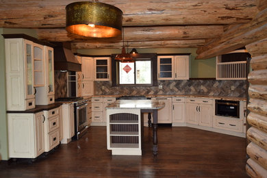 Eat-in kitchen - rustic u-shaped dark wood floor eat-in kitchen idea in Other with a farmhouse sink, raised-panel cabinets, white cabinets, granite countertops, beige backsplash, stone tile backsplash, stainless steel appliances and an island