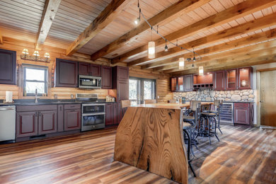 Eat-in kitchen - large rustic eat-in kitchen idea in St Louis with red cabinets, granite countertops, an island and black countertops