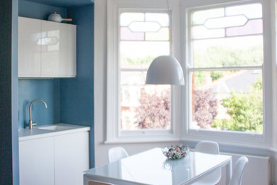 Idee per una piccola cucina abitabile minimalista con lavello integrato, top in quarzite, paraspruzzi blu e parquet chiaro