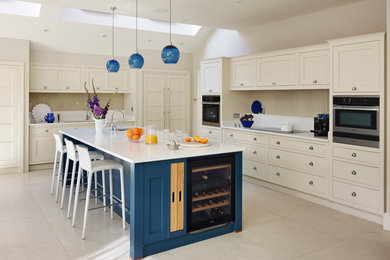 This is an example of an expansive contemporary open plan kitchen in London with shaker cabinets and an island.