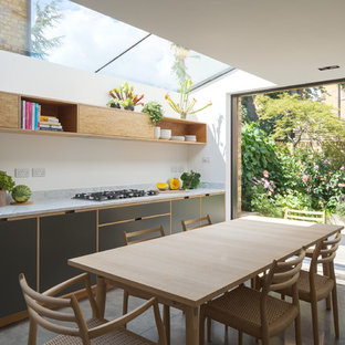 Inspiration for a modern kitchen in London with a submerged sink, flat-panel cabinets, marble worktops, integrated appliances, concrete flooring, no island and grey floors.