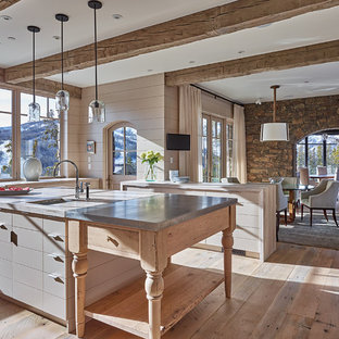 Large country u-shaped eat-in kitchen in Other with a farmhouse sink, flat-panel cabinets, grey cabinets, zinc benchtops, medium hardwood floors and with island.