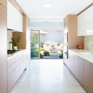 Ispirazione per una cucina parallela minimal di medie dimensioni con lavello sottopiano, ante lisce, ante in legno scuro, top in marmo, paraspruzzi bianco, paraspruzzi in marmo, elettrodomestici da incasso, pavimento in sughero, nessuna isola, pavimento bianco e top bianco