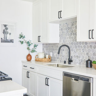 Foto di una piccola cucina parallela classica con lavello sottopiano, ante in stile shaker, ante bianche, paraspruzzi grigio, elettrodomestici in acciaio inossidabile e top bianco