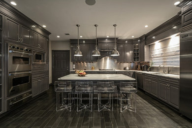 Example of a large transitional l-shaped porcelain tile kitchen design in New York with an undermount sink, stainless steel appliances, raised-panel cabinets, gray cabinets, marble countertops, metallic backsplash, metal backsplash and an island