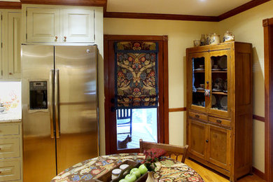 Example of a country galley light wood floor eat-in kitchen design in Charleston with an undermount sink, raised-panel cabinets, green cabinets, granite countertops, multicolored backsplash, stainless steel appliances and an island