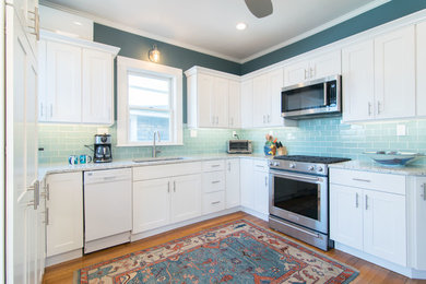 Enclosed kitchen - mid-sized transitional u-shaped medium tone wood floor and brown floor enclosed kitchen idea in Boston with an undermount sink, shaker cabinets, white cabinets, quartz countertops, blue backsplash, subway tile backsplash, stainless steel appliances, no island and white countertops