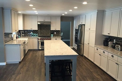 Eat-in kitchen - large transitional u-shaped dark wood floor eat-in kitchen idea in Los Angeles with a farmhouse sink, shaker cabinets, white cabinets, quartz countertops, black backsplash, porcelain backsplash, stainless steel appliances and an island