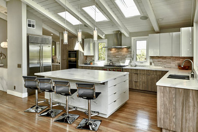 Open concept kitchen - large contemporary l-shaped light wood floor and brown floor open concept kitchen idea in San Francisco with an undermount sink, flat-panel cabinets, quartzite countertops, gray backsplash, travertine backsplash, stainless steel appliances, an island and white countertops