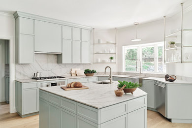 Example of a large minimalist u-shaped light wood floor and brown floor enclosed kitchen design in San Francisco with an undermount sink, shaker cabinets, green cabinets, quartzite countertops, gray backsplash, stone slab backsplash, stainless steel appliances, an island and gray countertops