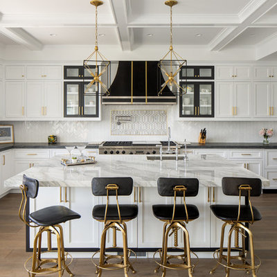 Inspiration for a transitional u-shaped medium tone wood floor and brown floor kitchen remodel in Los Angeles with an undermount sink, recessed-panel cabinets, white cabinets, white backsplash, mosaic tile backsplash, paneled appliances, an island and white countertops