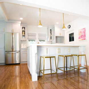 Idee per una cucina stile shabby di medie dimensioni con lavello stile country, ante in stile shaker, ante turchesi, top in quarzite, elettrodomestici in acciaio inossidabile, pavimento in legno massello medio, pavimento marrone e top bianco