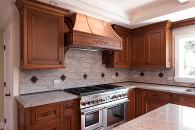 Foto på ett mellanstort vintage beige kök, med skåp i mellenmörkt trä, granitbänkskiva, grått stänkskydd, stänkskydd i stenkakel, rostfria vitvaror, ljust trägolv, en köksö, en undermonterad diskho och luckor med infälld panel