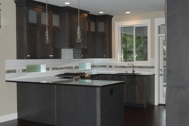 Example of a mid-sized transitional u-shaped dark wood floor open concept kitchen design in Vancouver with a single-bowl sink, shaker cabinets, distressed cabinets, granite countertops, white backsplash, porcelain backsplash, stainless steel appliances and a peninsula