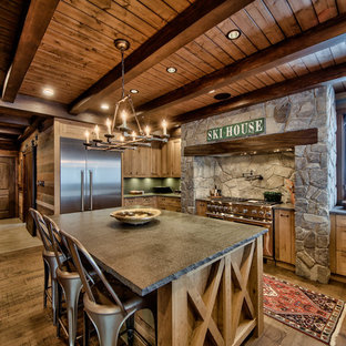 Ispirazione per una grande cucina a L rustica con ante con riquadro incassato, ante in legno chiaro, top in cemento, elettrodomestici in acciaio inossidabile, isola, pavimento in legno massello medio e paraspruzzi verde