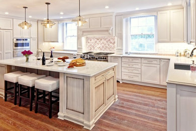 Eat-in kitchen - large transitional u-shaped medium tone wood floor eat-in kitchen idea in DC Metro with an undermount sink, flat-panel cabinets, white cabinets, quartz countertops, multicolored backsplash, glass tile backsplash, paneled appliances and an island