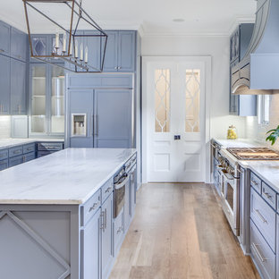 Réalisation d'une cuisine tradition avec un placard à porte shaker, des portes de placard violettes, un électroménager encastrable, un sol en bois clair, un îlot central, un sol beige et un plan de travail blanc.