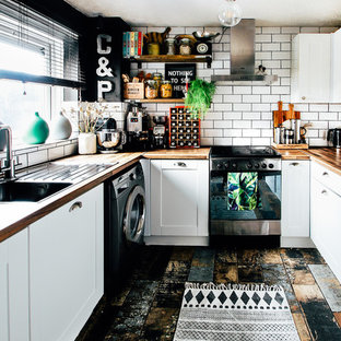Inspiration for a small eclectic u-shaped enclosed kitchen in Cardiff with a single-bowl sink, shaker cabinets, white cabinets, laminate countertops, white splashback, ceramic splashback, stainless steel appliances, multi-coloured floors and brown worktops.