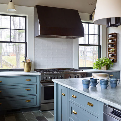 Inspiration for a mid-sized transitional l-shaped slate floor and gray floor enclosed kitchen remodel in Boston with a farmhouse sink, shaker cabinets, blue cabinets, quartzite countertops, white backsplash, subway tile backsplash, stainless steel appliances, an island and white countertops