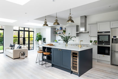 Eat-in kitchen - large transitional u-shaped gray floor eat-in kitchen idea in London with a double-bowl sink, shaker cabinets, blue cabinets, quartzite countertops and an island