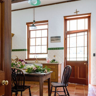 Idee per una cucina country con lavello stile country, ante con riquadro incassato, ante in legno chiaro, top in marmo, paraspruzzi bianco, paraspruzzi con piastrelle in ceramica, pavimento in terracotta, nessuna isola e elettrodomestici neri