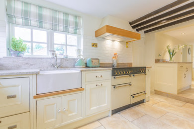 Photo of a small traditional kitchen/diner in Other with a belfast sink, beaded cabinets, white cabinets, granite worktops, coloured appliances, porcelain flooring, an island, multi-coloured floors and beige worktops.