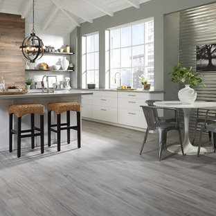 Ispirazione per una grande cucina abitabile contemporanea con ante lisce, ante bianche, top in granito, parquet scuro, penisola e pavimento grigio