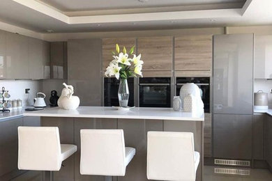 Inspiration for a contemporary u-shaped kitchen/diner in Cardiff with flat-panel cabinets, grey cabinets, quartz worktops and an island.