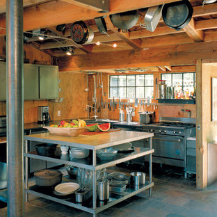 This is an example of a large country l-shaped open plan kitchen in San Francisco with a double-bowl sink, flat-panel cabinets, stainless steel cabinets, granite benchtops, stainless steel appliances, slate floors, with island, brown splashback, timber splashback and multi-coloured floor.
