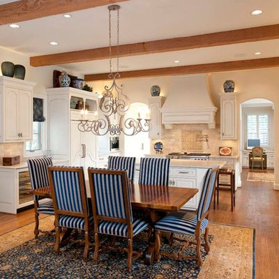 Elegant u-shaped eat-in kitchen photo in Dallas with a farmhouse sink, raised-panel cabinets, white cabinets, beige backsplash and paneled appliances
