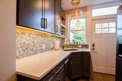 Example of a trendy galley light wood floor and brown floor eat-in kitchen design in DC Metro with an undermount sink, shaker cabinets, gray cabinets, quartz countertops, multicolored backsplash, mosaic tile backsplash, stainless steel appliances and multicolored countertops