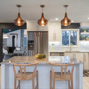 Aménagement d'une cuisine américaine scandinave en L de taille moyenne avec un évier encastré, un placard à porte plane, des portes de placard blanches, un plan de travail en quartz modifié, une crédence multicolore, une crédence en feuille de verre, un électroménager en acier inoxydable, un sol en contreplaqué et un îlot central.