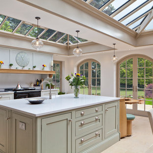 Photo of a large classic kitchen/diner in Other with beaded cabinets, green cabinets, black appliances and an island.