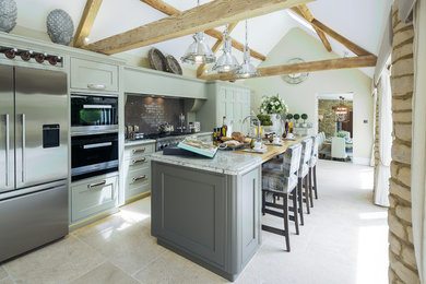 Design ideas for a large country l-shaped enclosed kitchen in Gloucestershire with a submerged sink, shaker cabinets, green cabinets, granite worktops, ceramic splashback, stainless steel appliances, limestone flooring and an island.