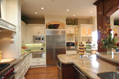 Design ideas for a traditional kitchen in Orange County with raised-panel cabinets, white cabinets, granite worktops, stainless steel appliances, medium hardwood flooring and an island.
